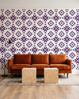 Pale Kilim Plum kilim wallpaper behind a rust velvet sofa in a bright coworking lounge