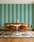 Parlor Stripe Emerald geometric stripe wallpaper in a mid-century dining room with a teak sideboard and tulip table