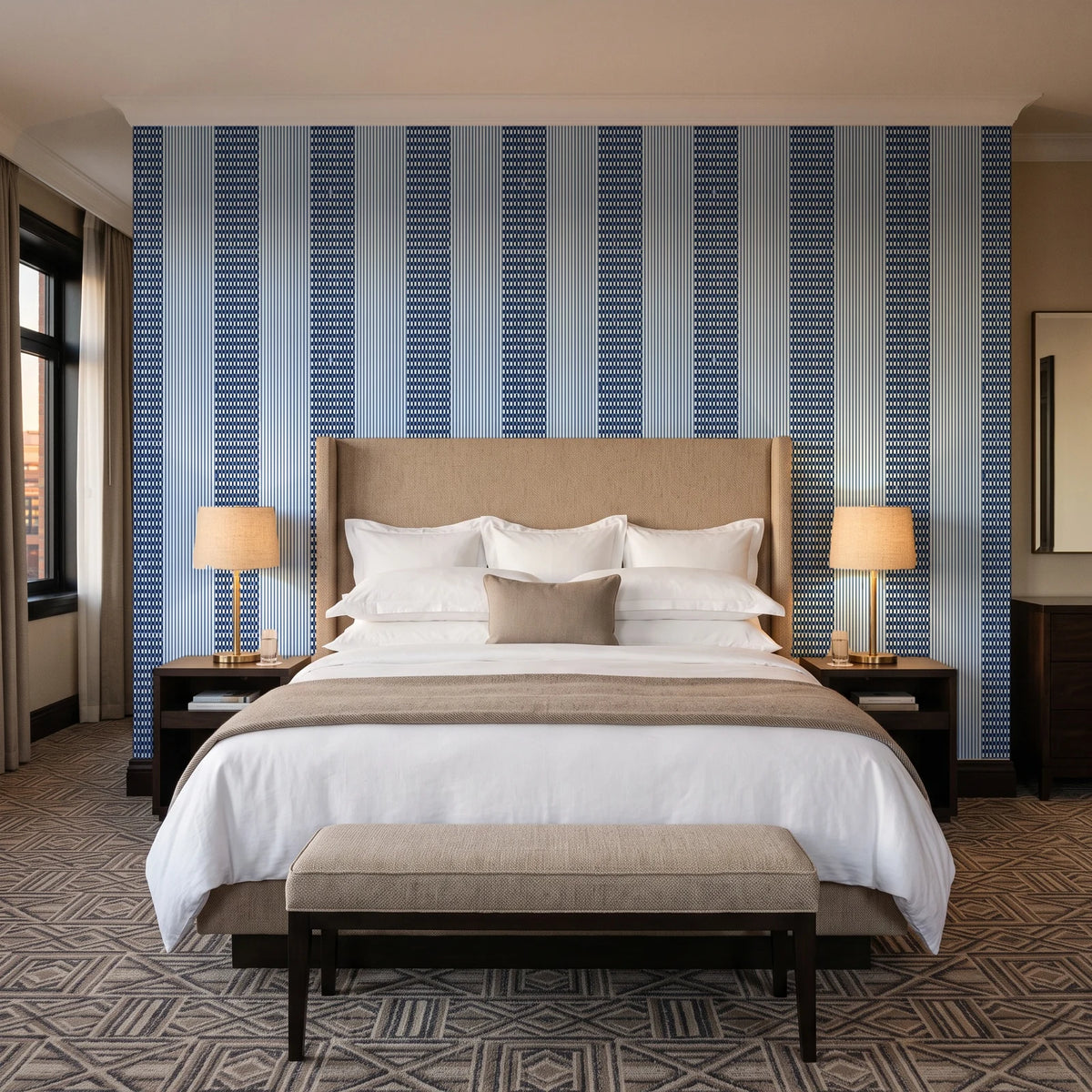 Parlor Stripe Midnight geometric stripe wallpaper behind the headboard of a king bed in a contemporary hotel guest room