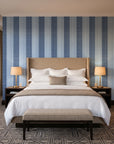 Parlor Stripe Midnight geometric stripe wallpaper behind the headboard of a king bed in a contemporary hotel guest room