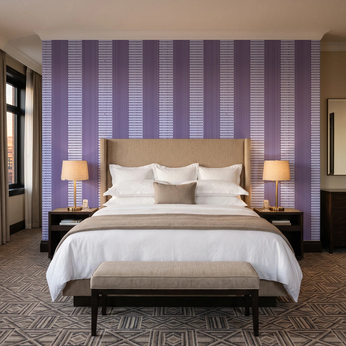 Parlor Stripe Plum geometric stripe wallpaper behind the headboard of a king bed in a contemporary hotel guest room