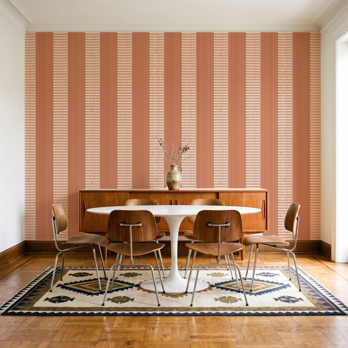 Parlor Stripe Terracotta geometric stripe wallpaper in a mid-century dining room with a teak sideboard and tulip table