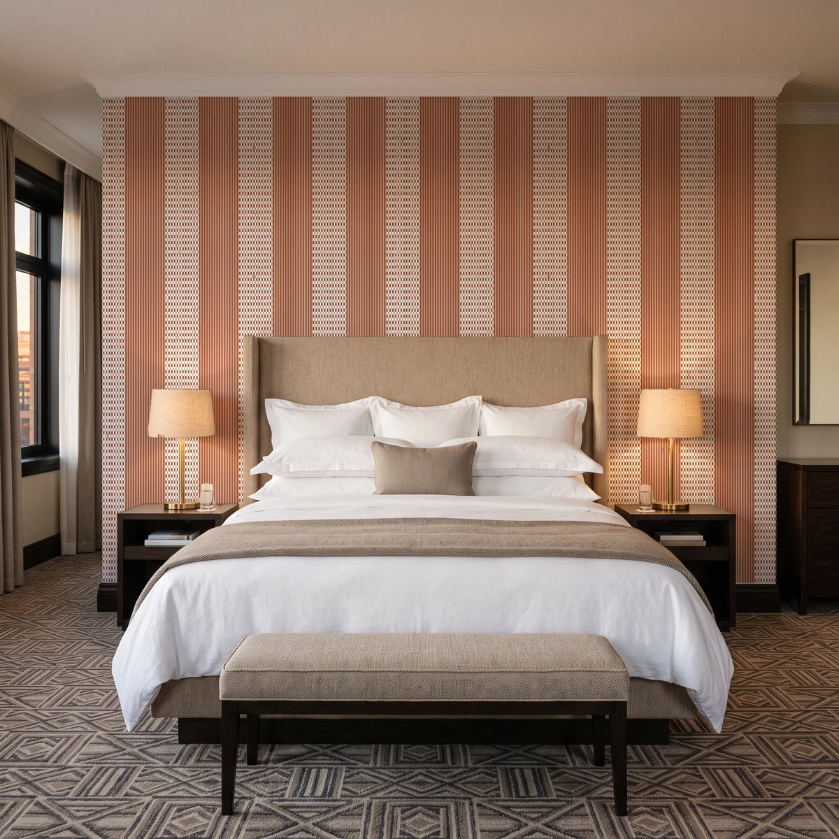 Parlor Stripe Terracotta geometric stripe wallpaper behind the headboard of a king bed in a contemporary hotel guest room