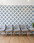 Pastel Bouquet Parade Navy botanical damask wallpaper behind a row of upholstered chairs in a bright clinic waiting room