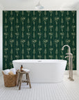 Petal & Thread Emerald botanical stem wallpaper behind a freestanding tub in a bright coastal bathroom