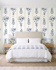 Petal & Thread Indigo botanical stem wallpaper behind a queen bed in a bright coastal bedroom