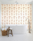 Petal & Thread Terracotta botanical stem wallpaper behind a freestanding tub in a bright coastal bathroom