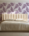 Pewter Fern Plum fern wallpaper behind a channel-tufted bed in a calm primary bedroom