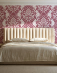 Poet's Blossom Dusty Rose classic damask wallpaper behind a channel-tufted bed in a calm primary bedroom