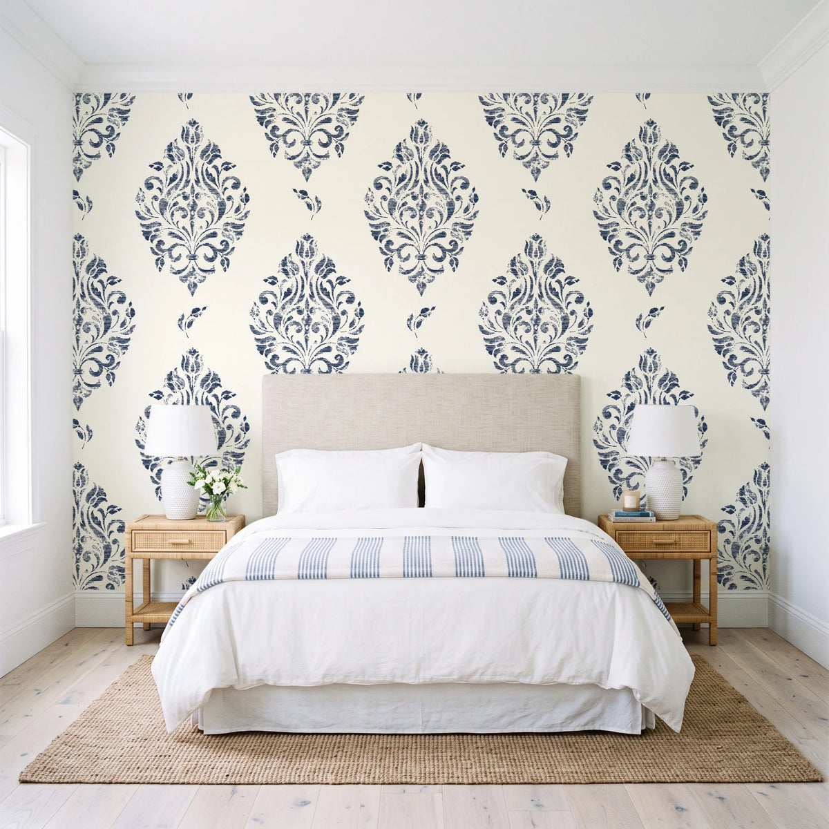 Porcelain Bouquet Inkwell damask wallpaper behind a queen bed in a bright coastal bedroom