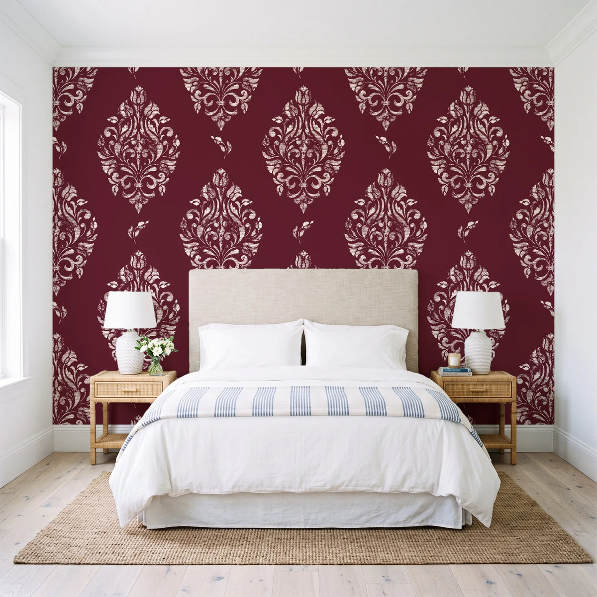 Porcelain Bouquet Oxblood damask wallpaper behind a queen bed in a bright coastal bedroom