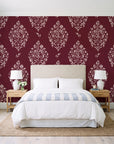 Porcelain Bouquet Oxblood damask wallpaper behind a queen bed in a bright coastal bedroom
