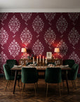 Porcelain Bouquet Oxblood damask wallpaper in a dark moody dining room with a candlelit table