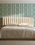 Porcelain Filigree Emerald filigree damask wallpaper behind a channel-tufted bed in a calm primary bedroom
