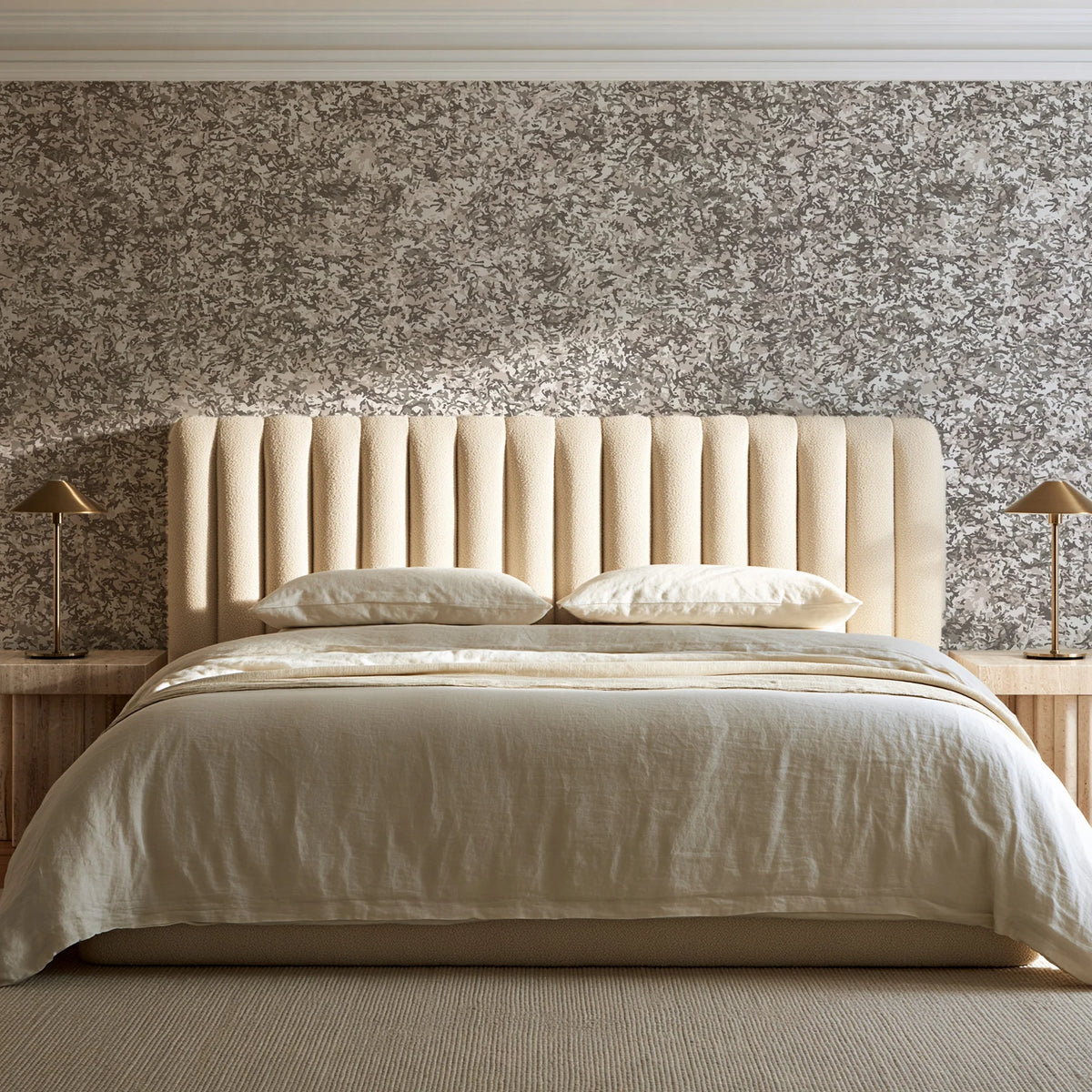 Quiet Camo Greige abstract wallpaper behind a channel-tufted bed in a calm primary bedroom