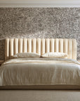 Quiet Camo Greige abstract wallpaper behind a channel-tufted bed in a calm primary bedroom
