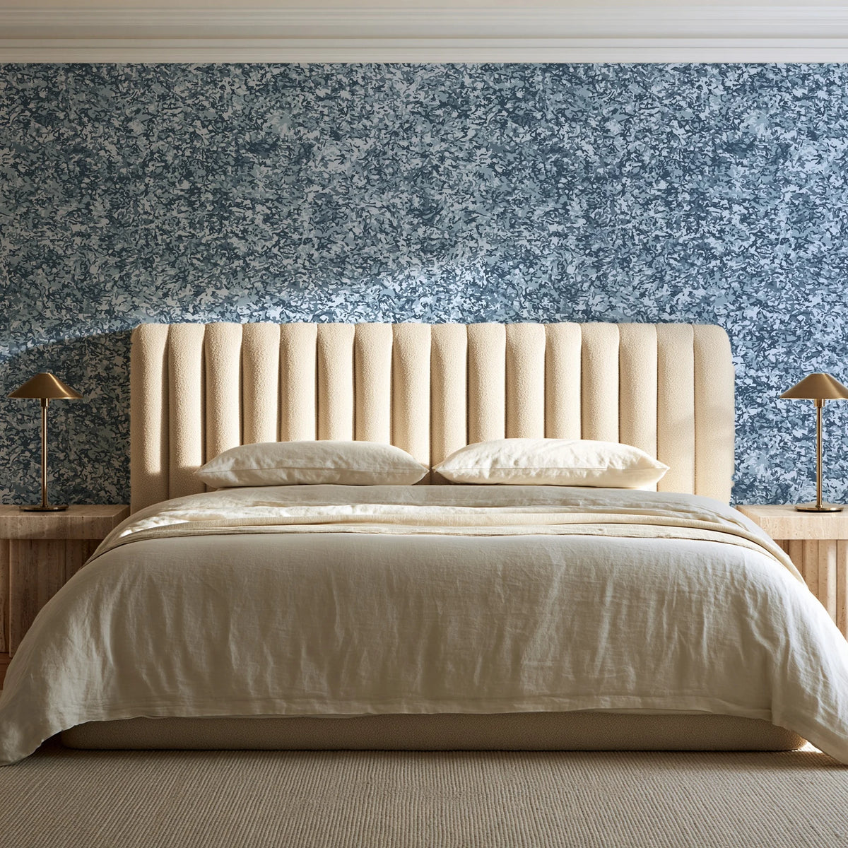 Quiet Camo Slate abstract wallpaper behind a channel-tufted bed in a calm primary bedroom