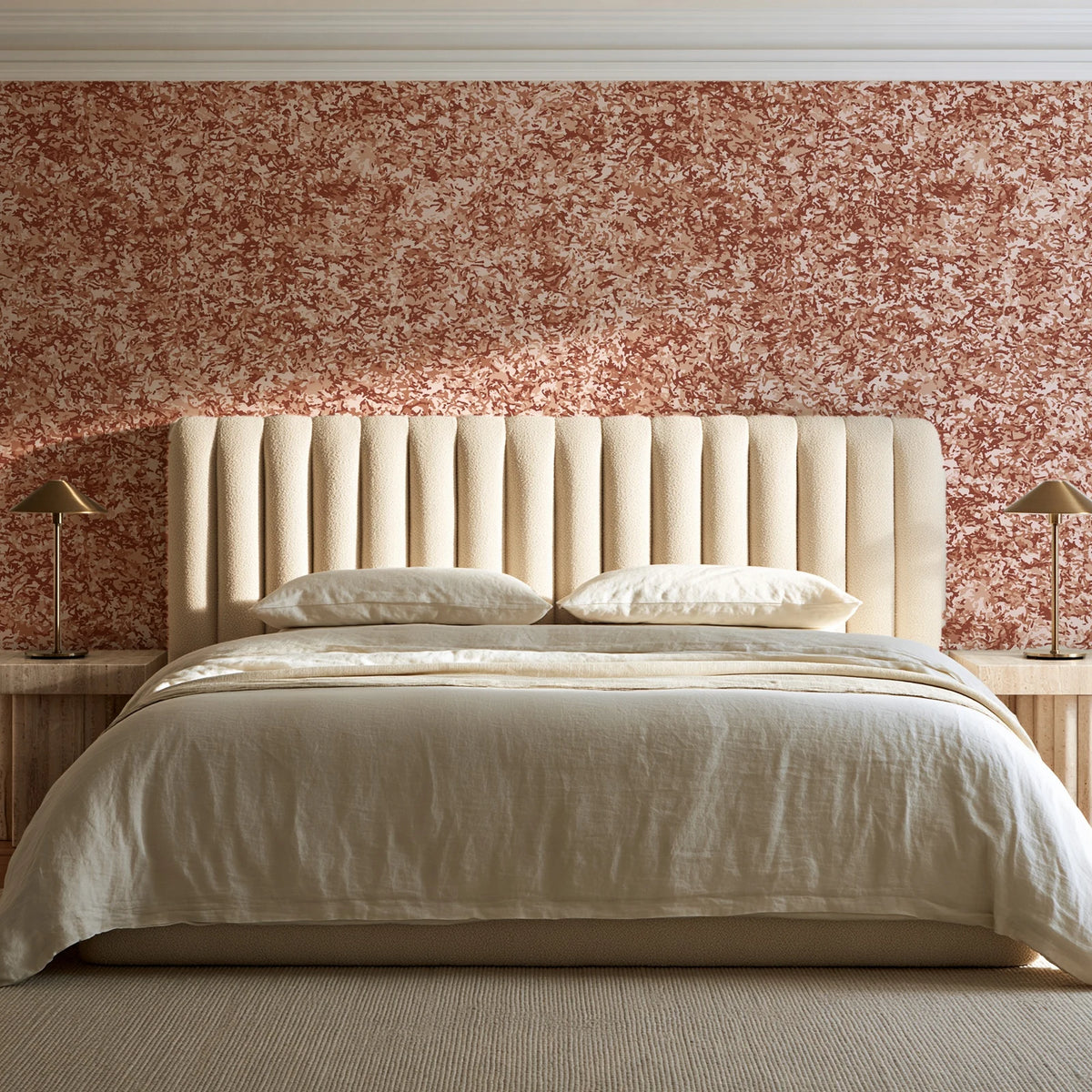 Quiet Camo Terracotta abstract wallpaper behind a channel-tufted bed in a calm primary bedroom