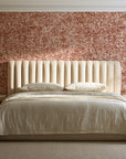 Quiet Camo Terracotta abstract wallpaper behind a channel-tufted bed in a calm primary bedroom