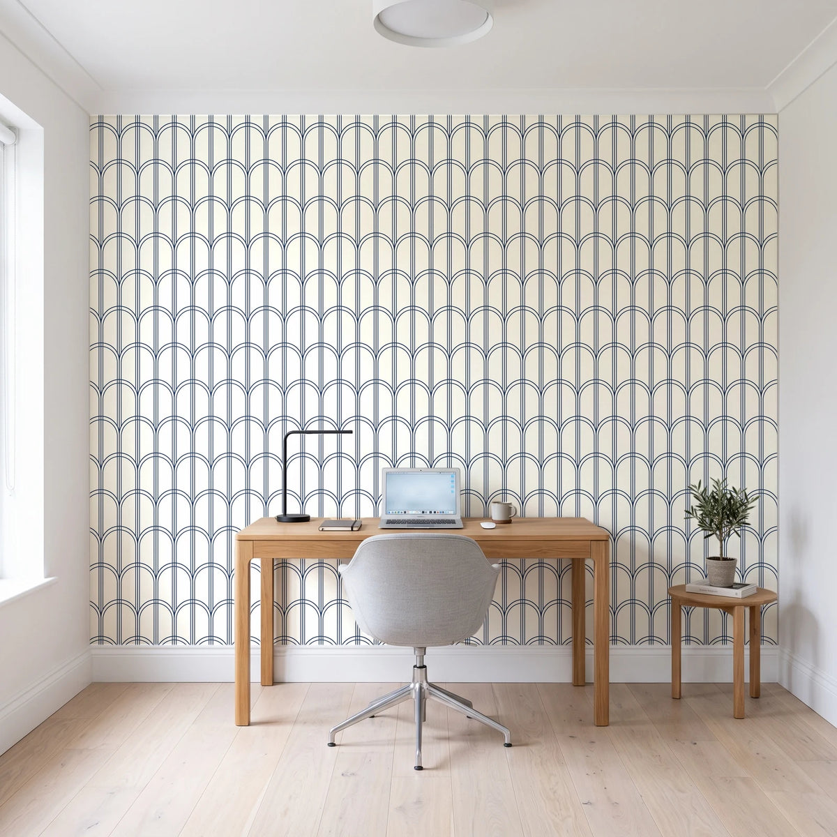 Quiet Grace Midnight minimalist arch wallpaper behind a modern oak desk in a bright home office