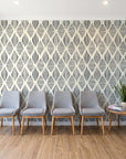 Reed & Smoke Ink geometric wallpaper behind a row of upholstered chairs in a bright clinic waiting room