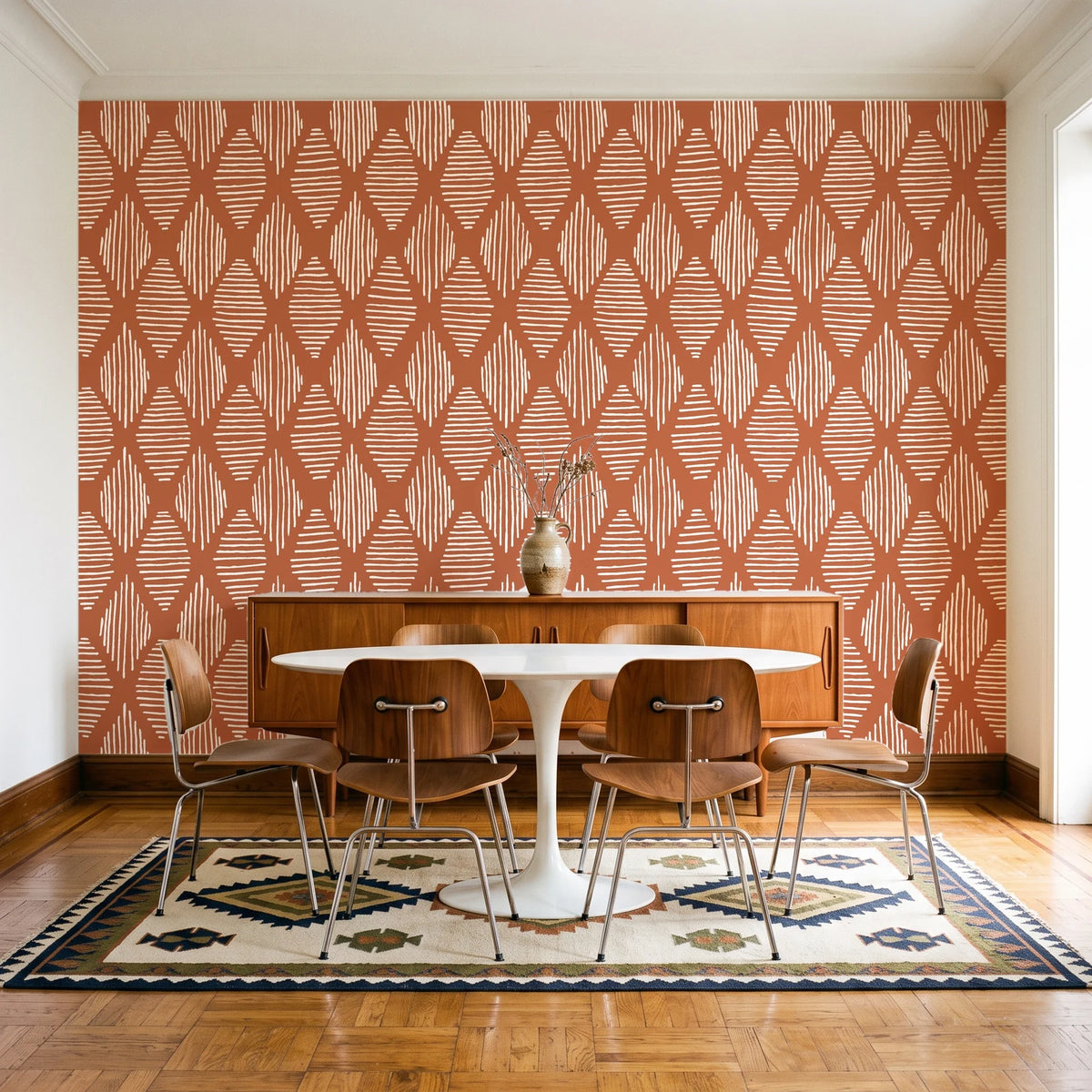 Reed & Smoke Terracotta geometric wallpaper in a mid-century dining room with a teak sideboard and tulip table
