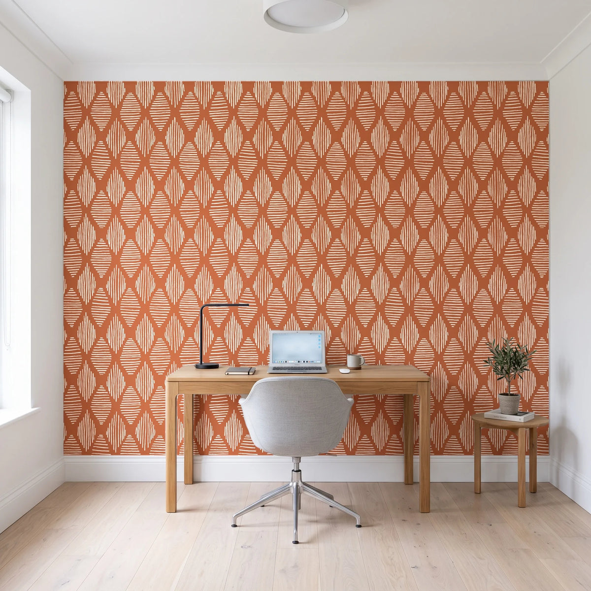 Reed & Smoke Terracotta geometric wallpaper behind a modern oak desk in a bright home office