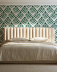 Rising Arrow Emerald geometric wallpaper behind a channel-tufted bed in a calm primary bedroom