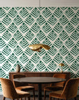Rising Arrow Emerald geometric wallpaper behind a walnut credenza and round table in an elegant dining room