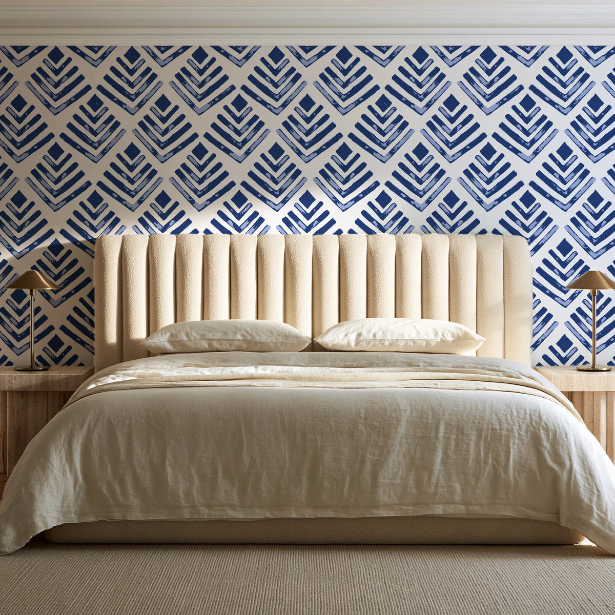 Rising Arrow Indigo geometric wallpaper behind a channel-tufted bed in a calm primary bedroom