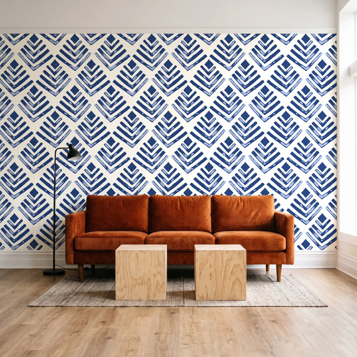 Rising Arrow Indigo geometric wallpaper behind a rust velvet sofa in a bright coworking lounge