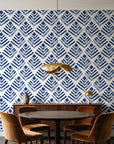 Rising Arrow Indigo geometric wallpaper behind a walnut credenza and round table in an elegant dining room