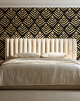 Rising Arrow Noir geometric wallpaper behind a channel-tufted bed in a calm primary bedroom