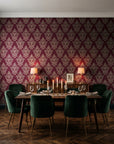 Rosewater Retreat Oxblood damask wallpaper in a dark moody dining room with a candlelit table