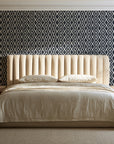 Sage Trellis Charcoal geometric wallpaper behind a channel-tufted bed in a calm primary bedroom