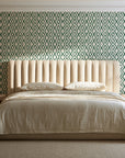Sage Trellis Forest geometric wallpaper behind a channel-tufted bed in a calm primary bedroom