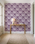 Secret Arbor Plum damask wallpaper behind a console table in a light entry hallway