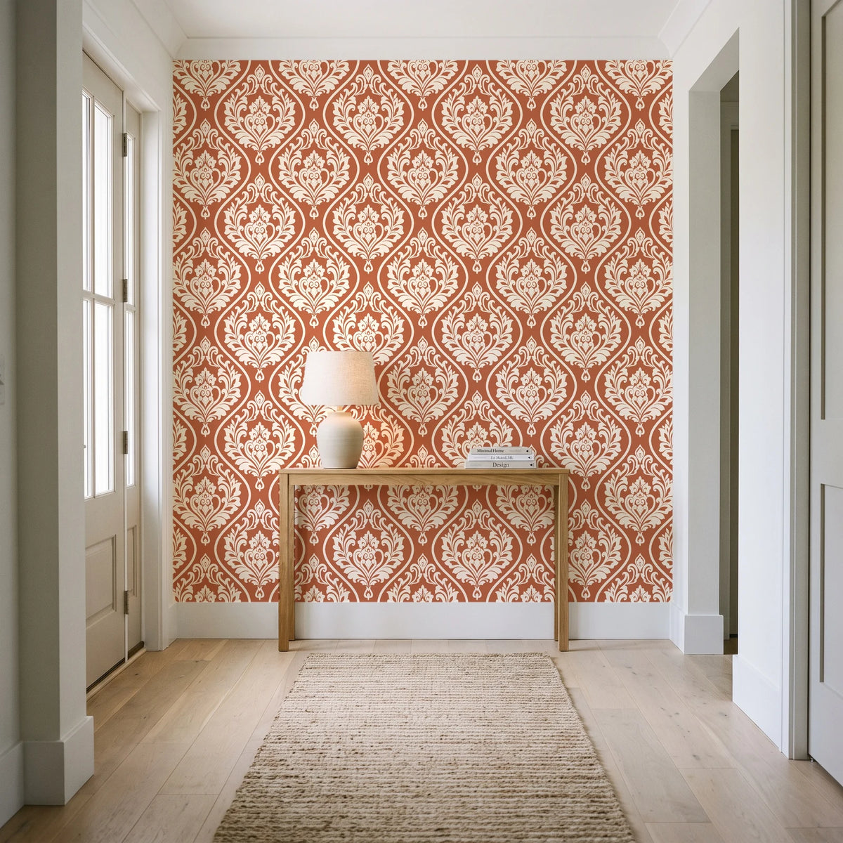 Secret Arbor Terracotta damask wallpaper behind a console table in a light entry hallway