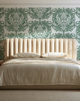 Serene Blossom Sage damask wallpaper behind a channel-tufted bed in a calm primary bedroom