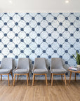 Shadow Garden Navy lattice floral wallpaper behind a row of upholstered chairs in a bright clinic waiting room