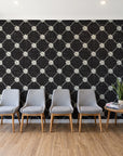 Shadow Garden Onyx lattice floral wallpaper behind a row of upholstered chairs in a bright clinic waiting room