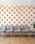 Shadow Garden Terracotta lattice floral wallpaper behind a row of upholstered chairs in a bright clinic waiting room