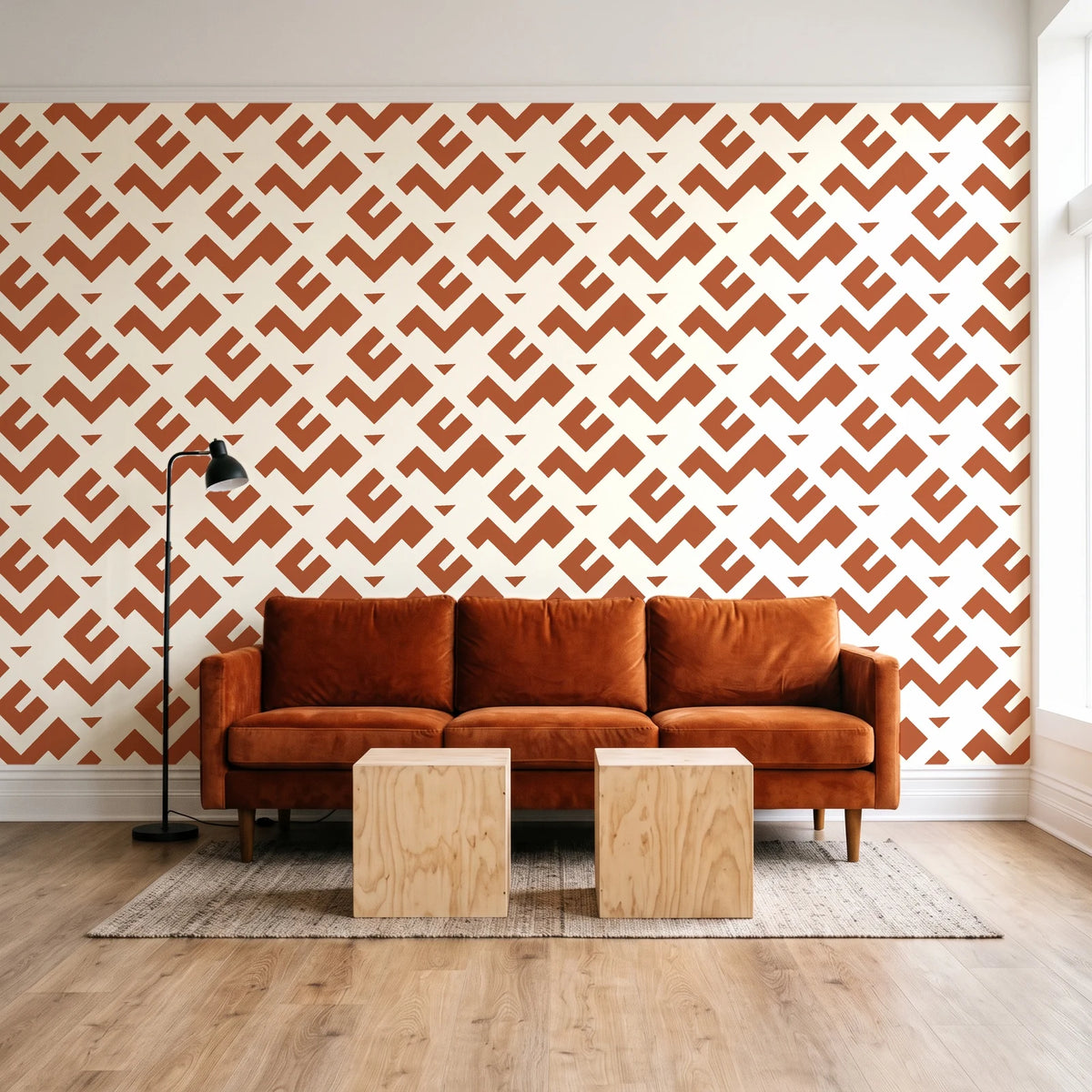 Signal & Edge Terracotta geometric wallpaper behind a rust velvet sofa in a bright coworking lounge