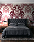 Silent Bouquet Oxblood damask wallpaper behind a tufted headboard in a dark, moody bedroom