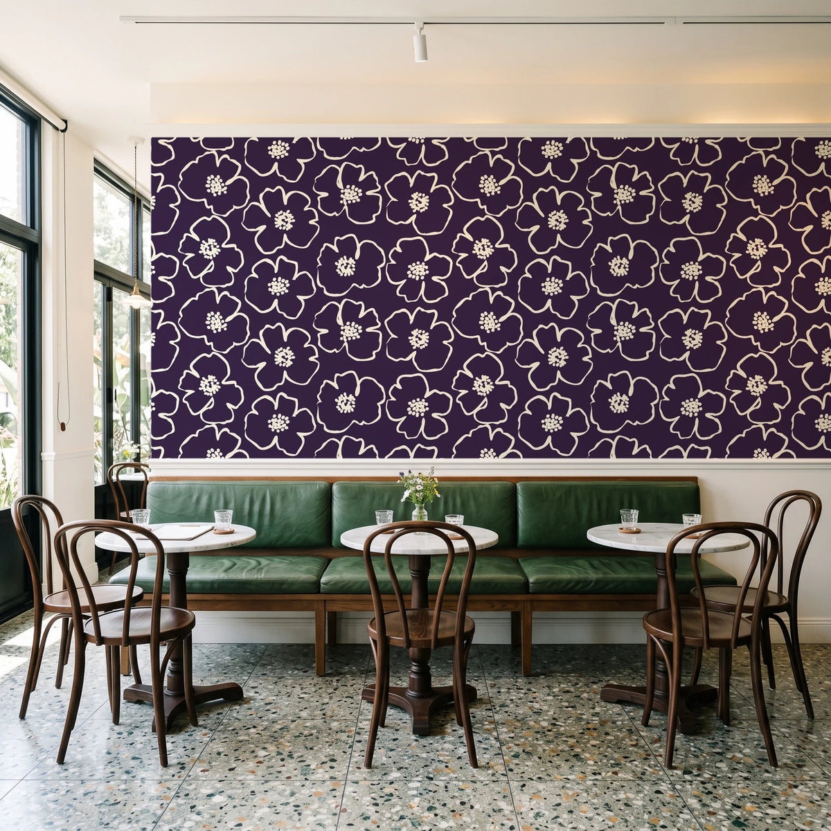 Sketch Anemone Aubergine sketched anemone wallpaper above a green leather banquette in a sunlit neighborhood cafe