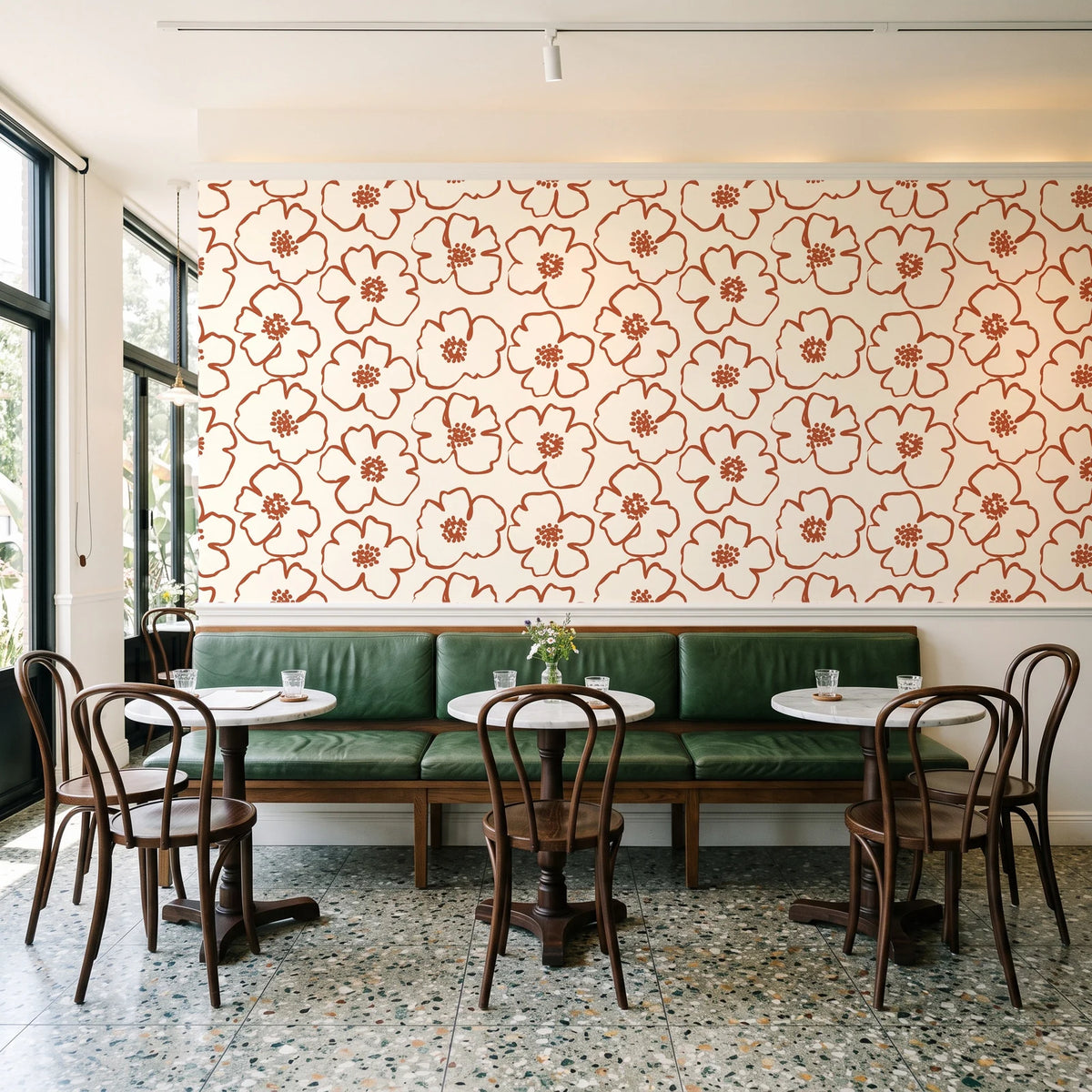 Sketch Anemone Terracotta sketched anemone wallpaper above a green leather banquette in a sunlit neighborhood cafe