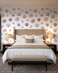 Sketched Seashells Coral seashell wallpaper behind the headboard of a king bed in a contemporary hotel guest room
