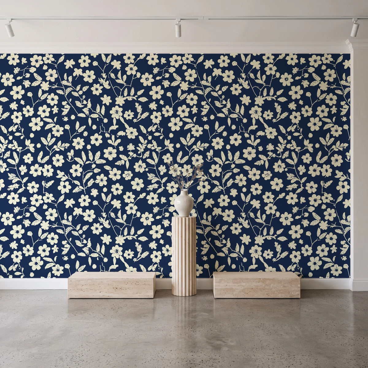 Sky Bloom Midnight floral wallpaper behind a travertine pedestal and vase in a minimal boutique