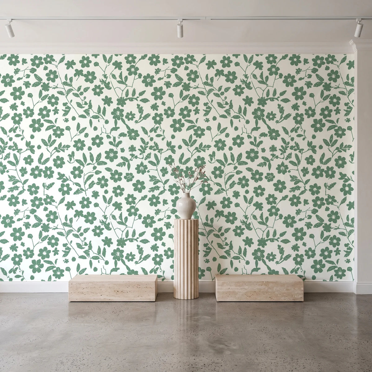 Sky Bloom Sage floral wallpaper behind a travertine pedestal and vase in a minimal boutique