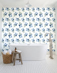 Sky Memory Midnight watercolor floral wallpaper behind a freestanding tub in a bright coastal bathroom